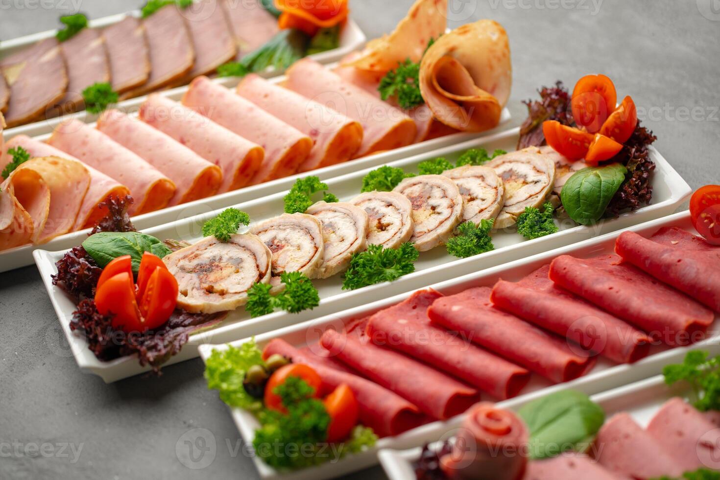 Platter of fresh meat cold cuts with vegetables. photo