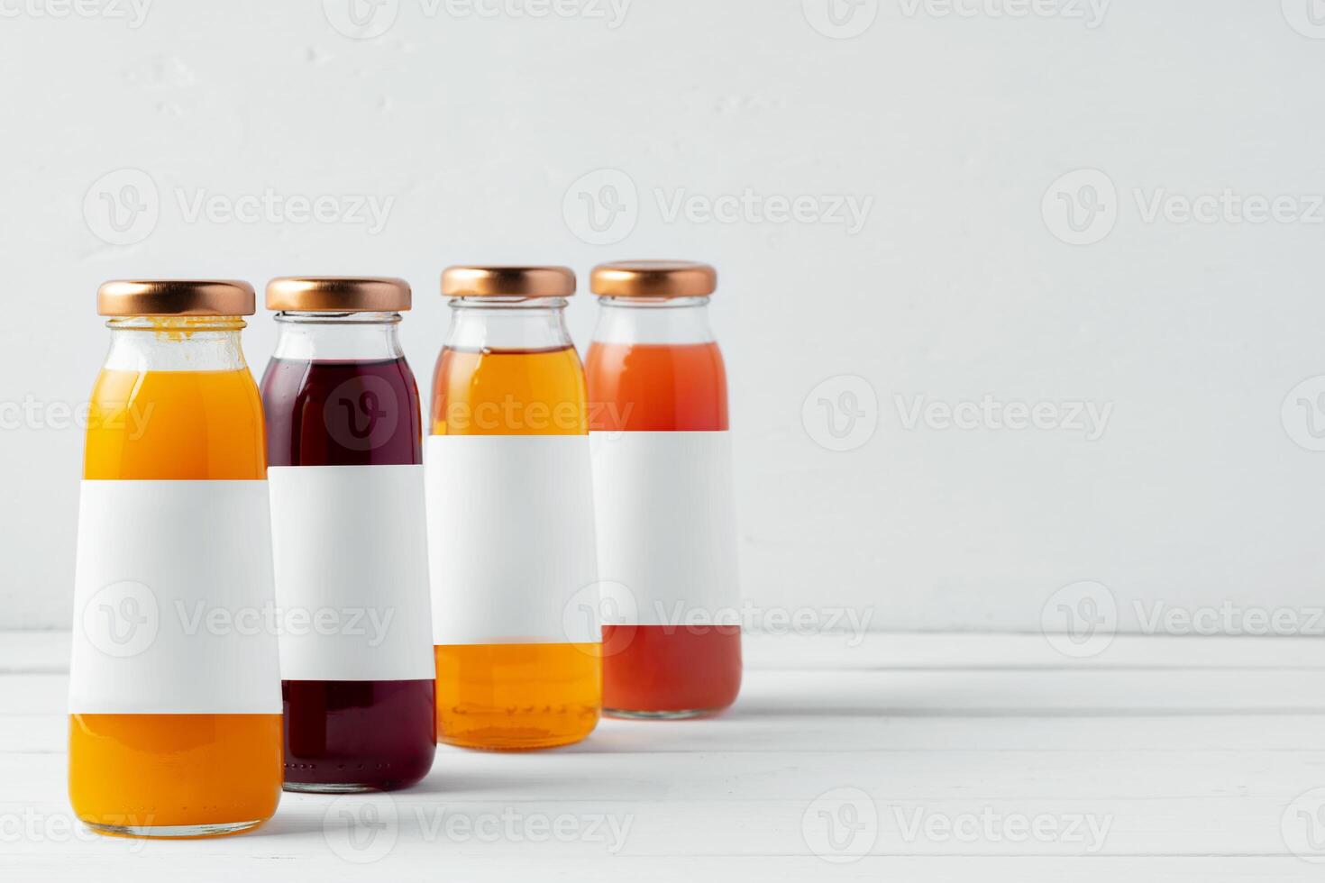 Glass bottles of different juices on white background photo