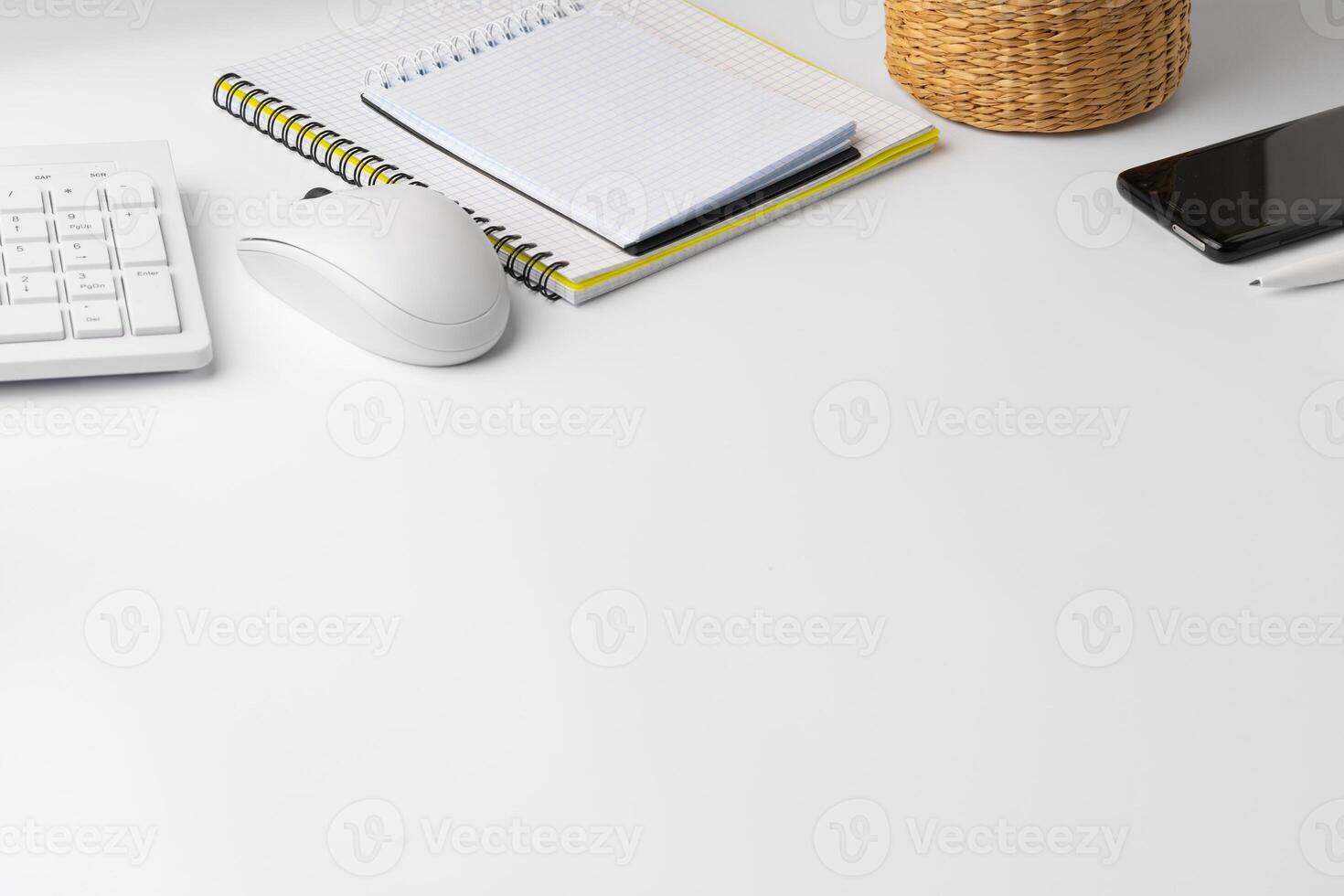 Creative white table with blank cellphone and supplies photo