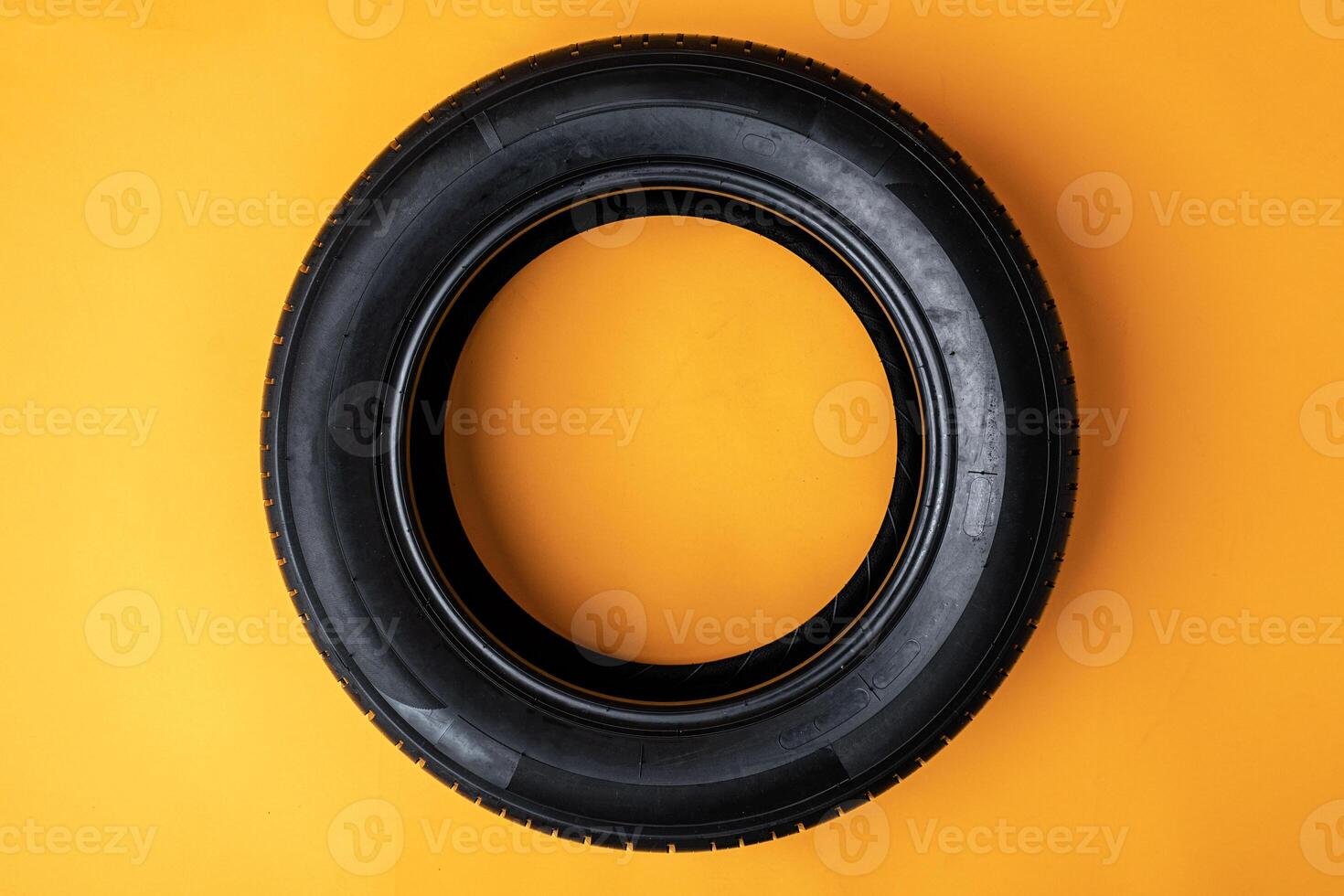 Car tires isolated on yellow background, close up photo