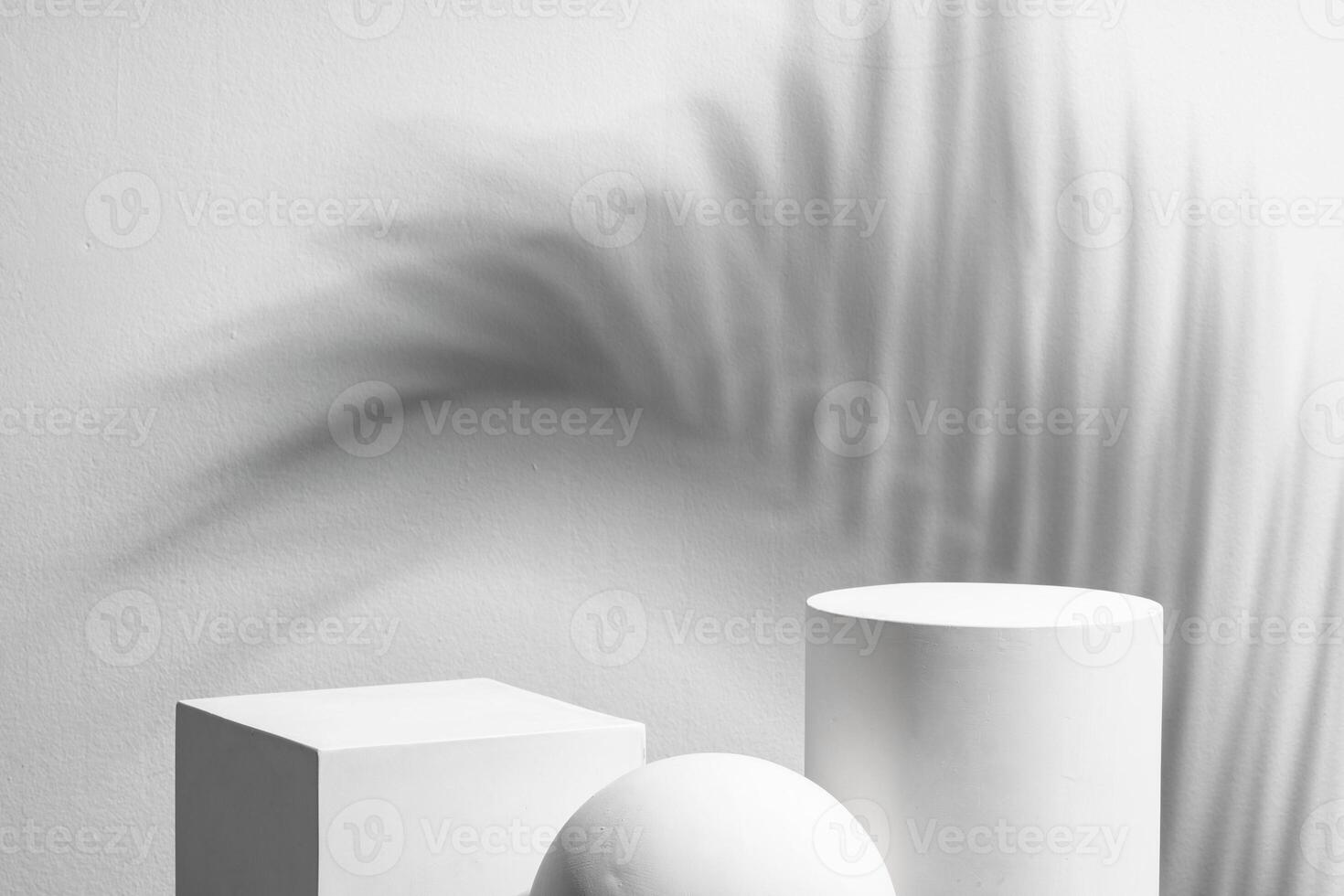 Abstract composition featuring three white geometric shapes in a minimalist interior setting photo