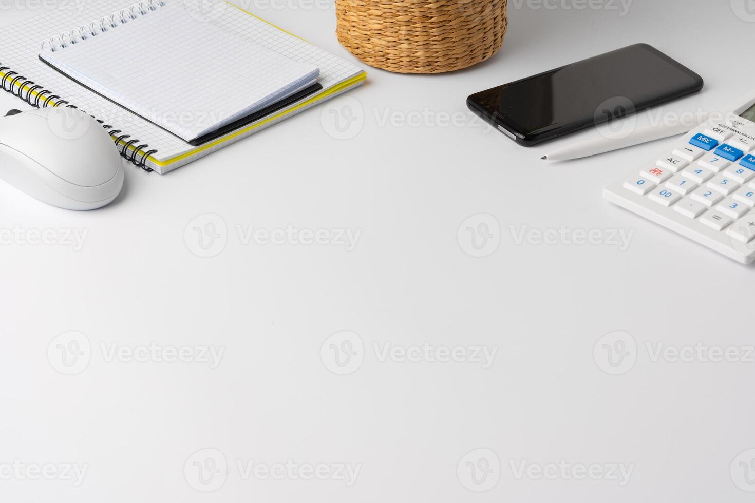 Creative white table with blank cellphone and supplies photo