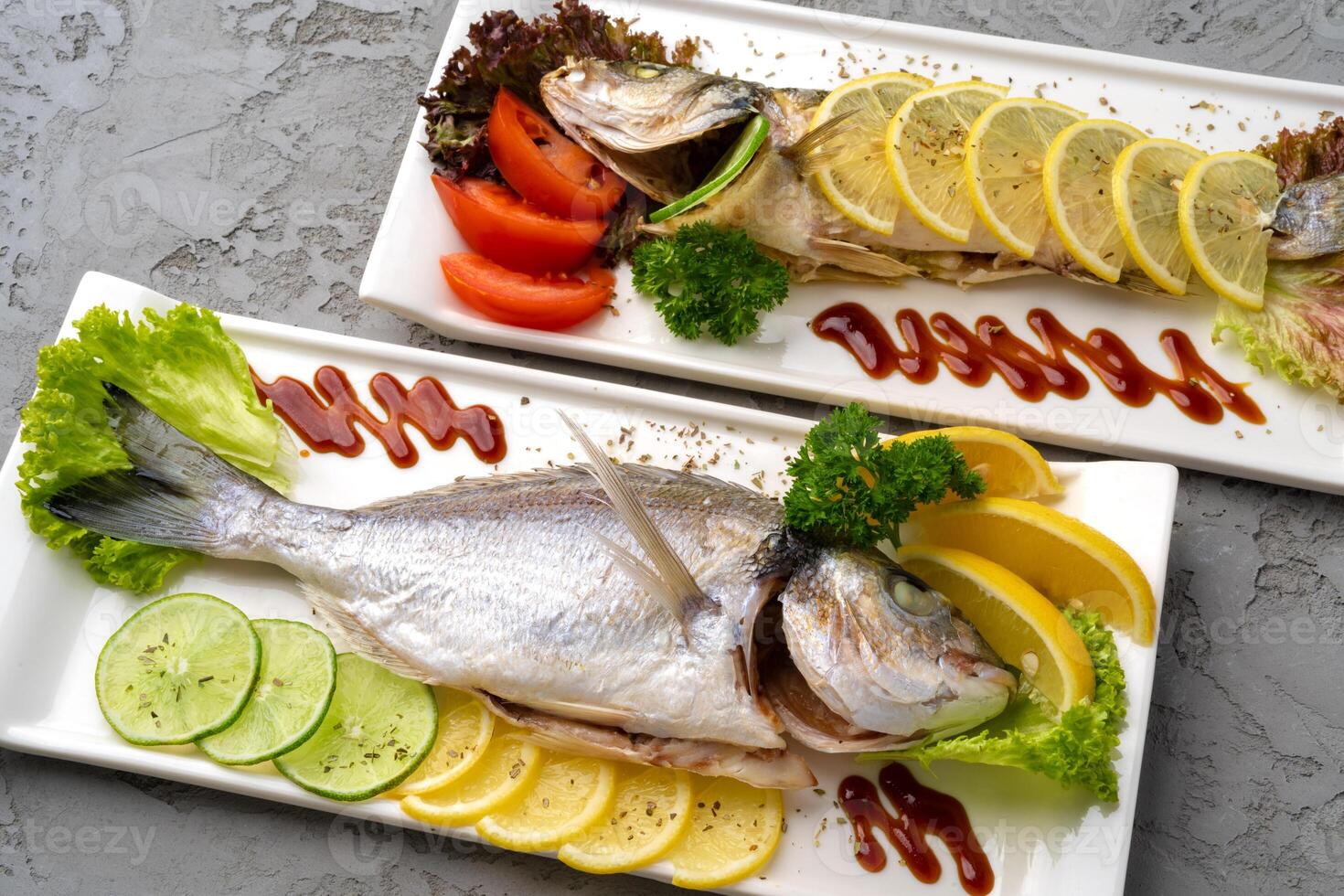Fresh sea fish with lemon on plate photo