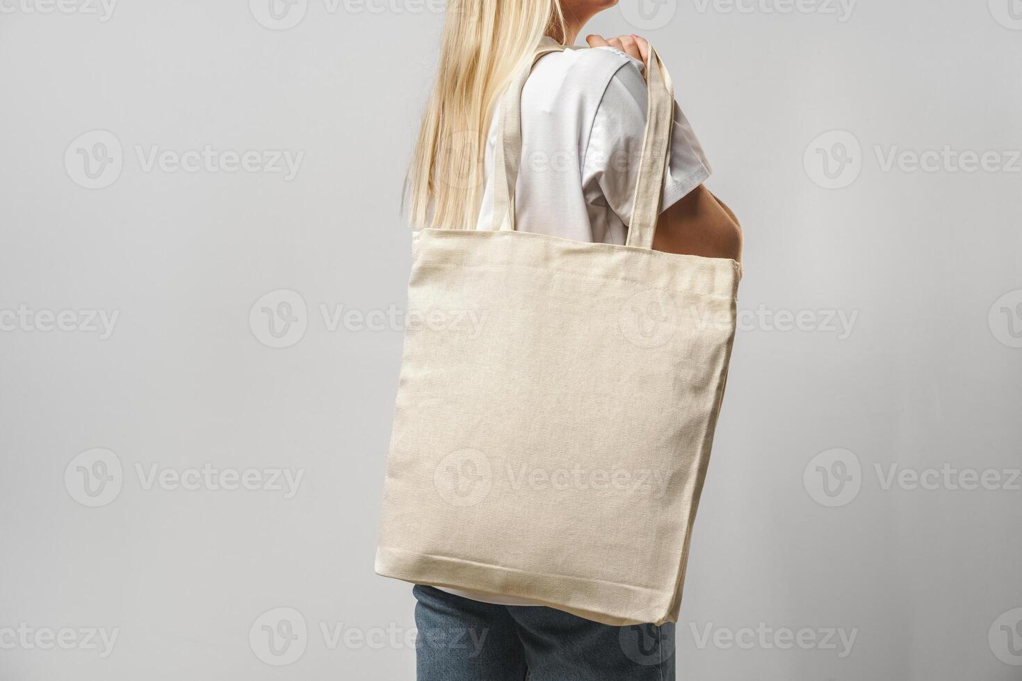 Cropped image of woman holding beige shopping bag in studio photo
