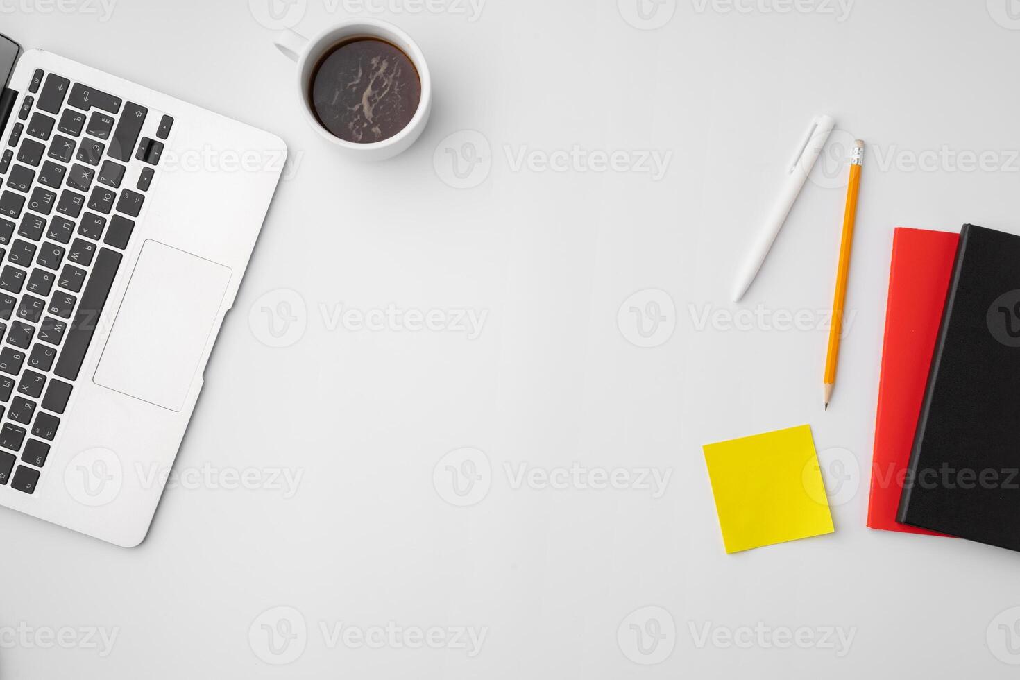 Office desk with laptop, blank notebook and coffee cup photo