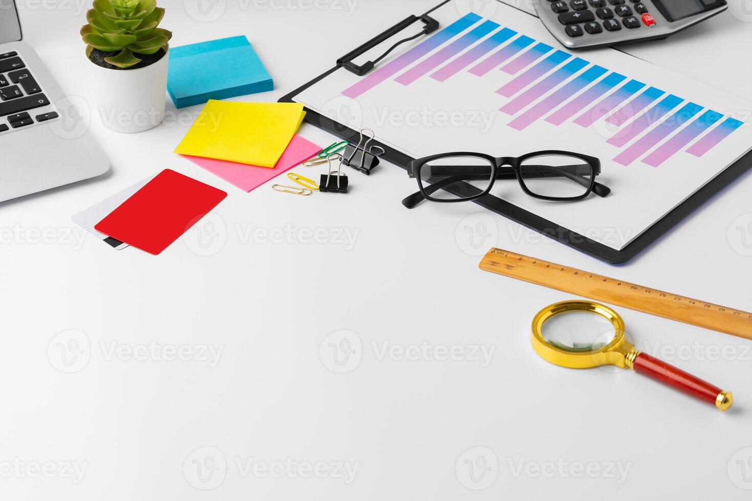 Paper statistics charts and laptop keyboard on white table photo