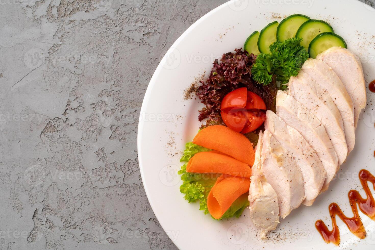 Roast chicken fillets and vegetables on gray background photo