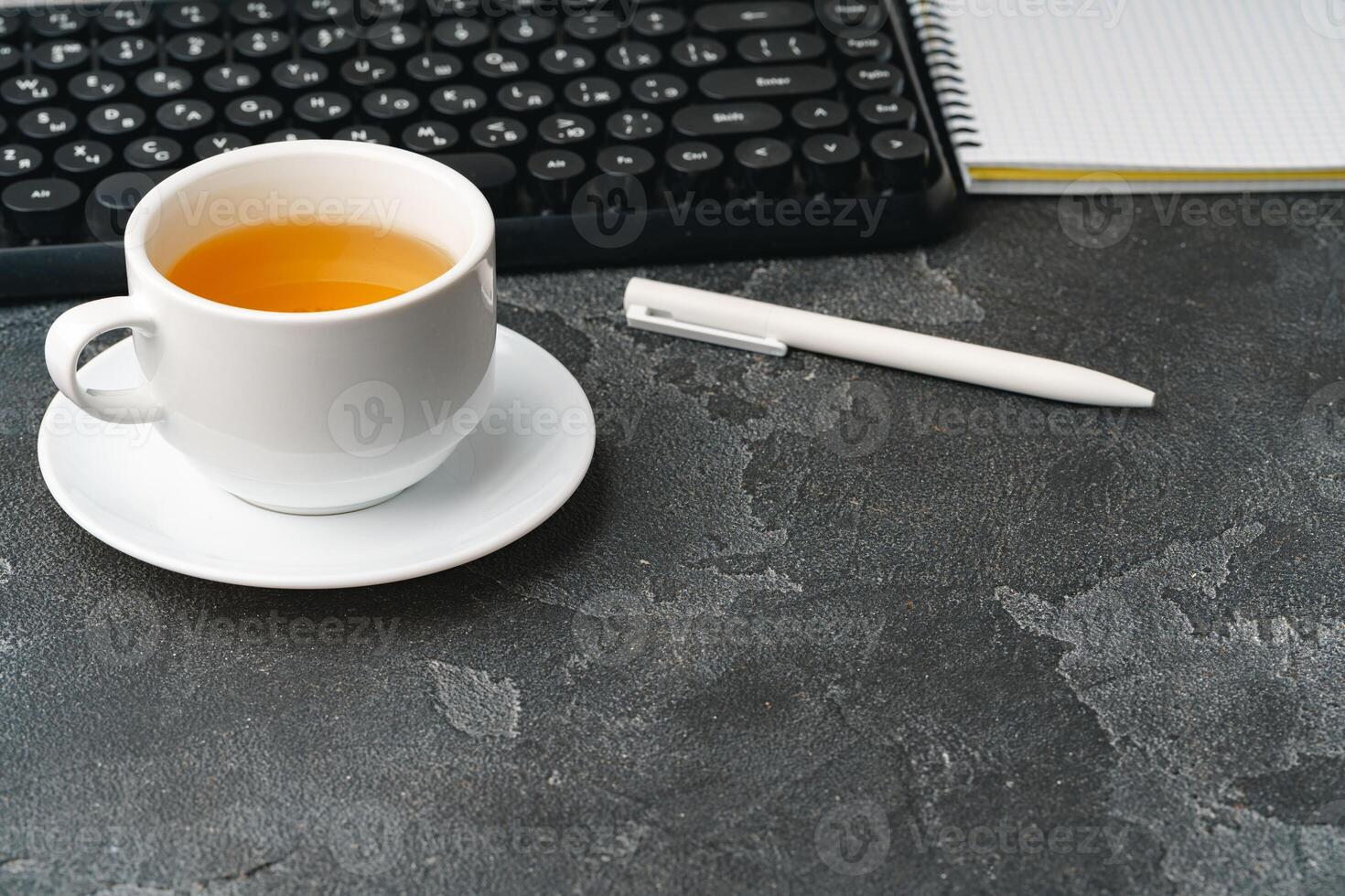 Office desk with computer keyboard, notepad and pen photo