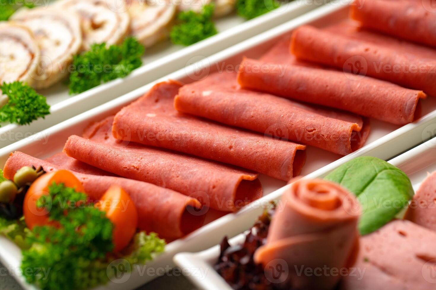 Platter of fresh meat cold cuts with vegetables. photo