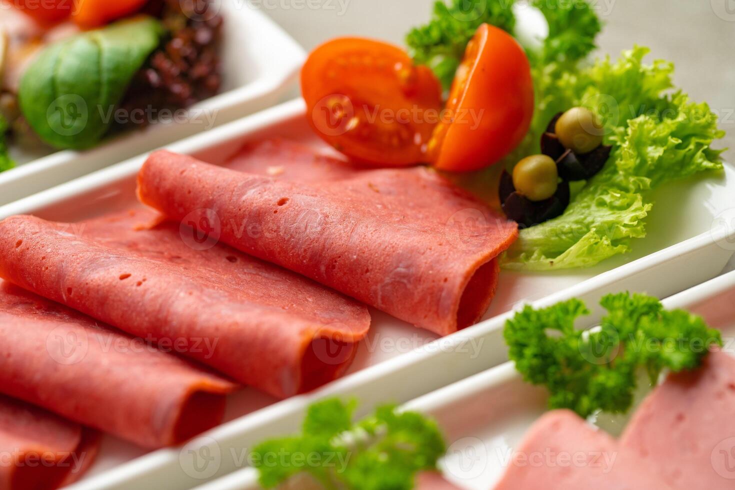 Platter of fresh meat cold cuts with vegetables. photo