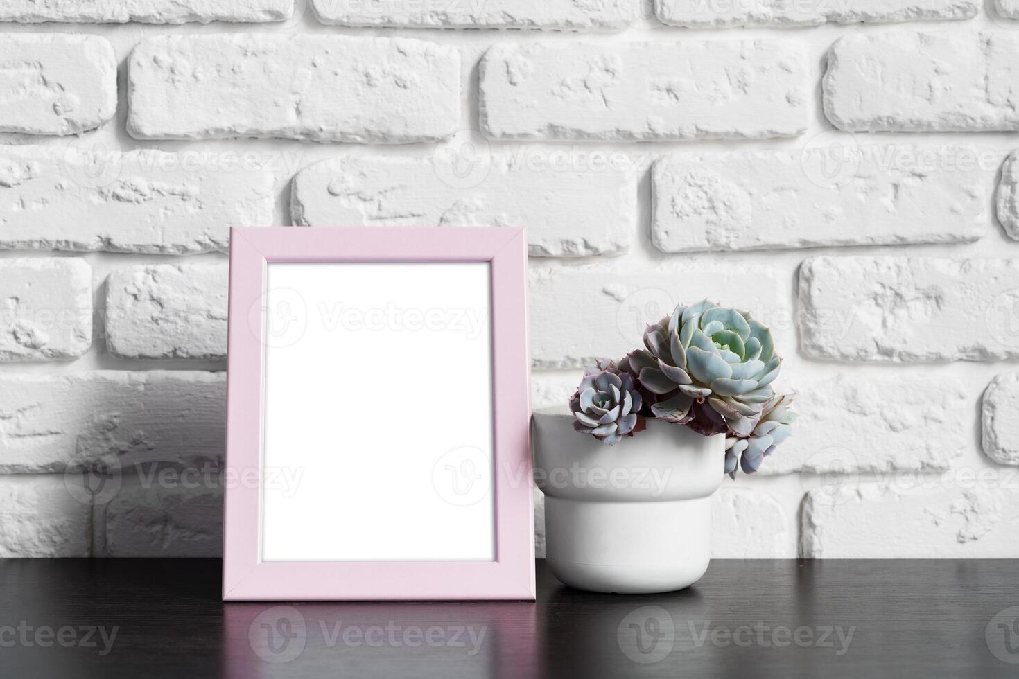 Wooden picture frame on a table with cactus photo