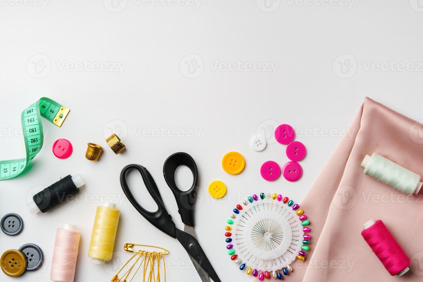 Crafting supplies arranged on a table with fabric, thread and buttons during daytime photo