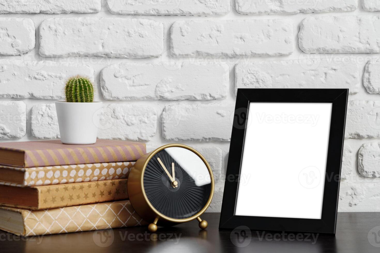 Books with picture frame on wooden table photo
