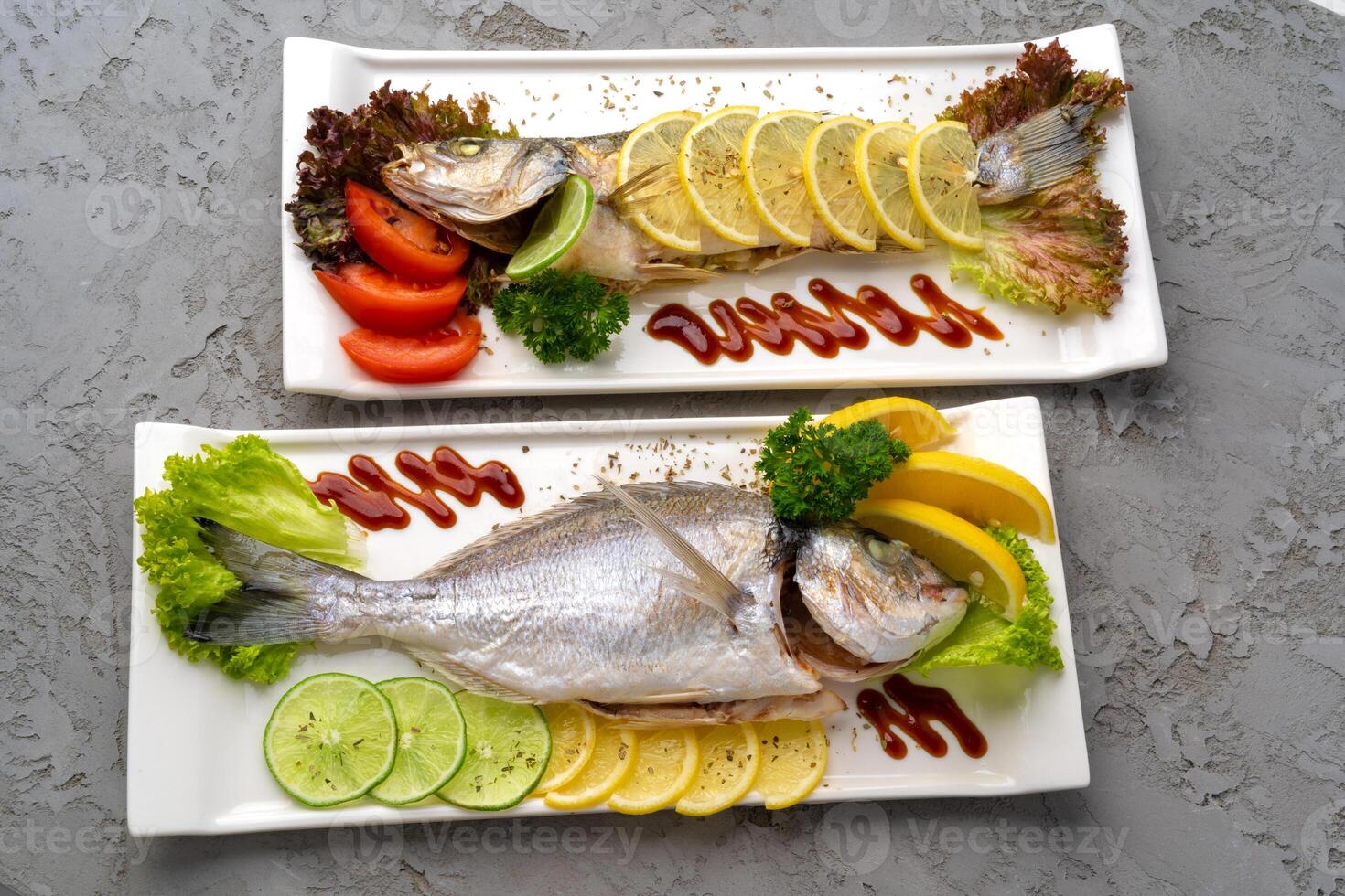 Fresh sea fish with lemon on plate photo