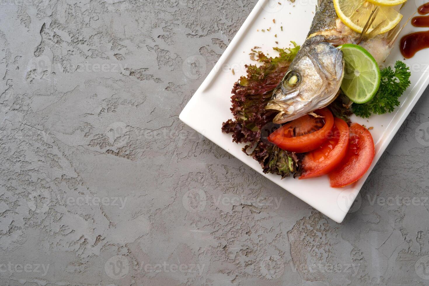 Fresh sea fish with lemon on plate photo