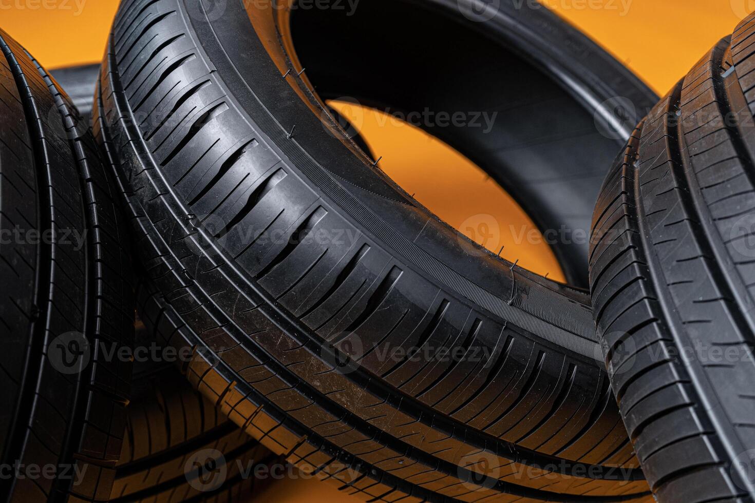 Car tires isolated on yellow background, close up photo