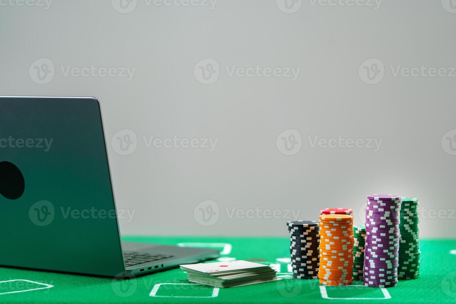 Online poker game setup with colorful chips and playing cards on a green table photo