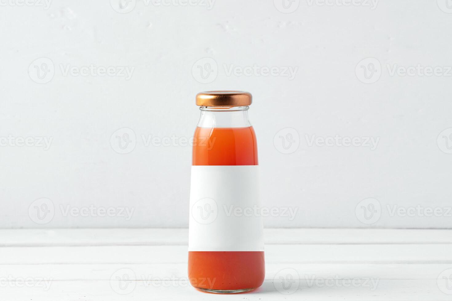 Small glass bottle of fresh juice on white background photo