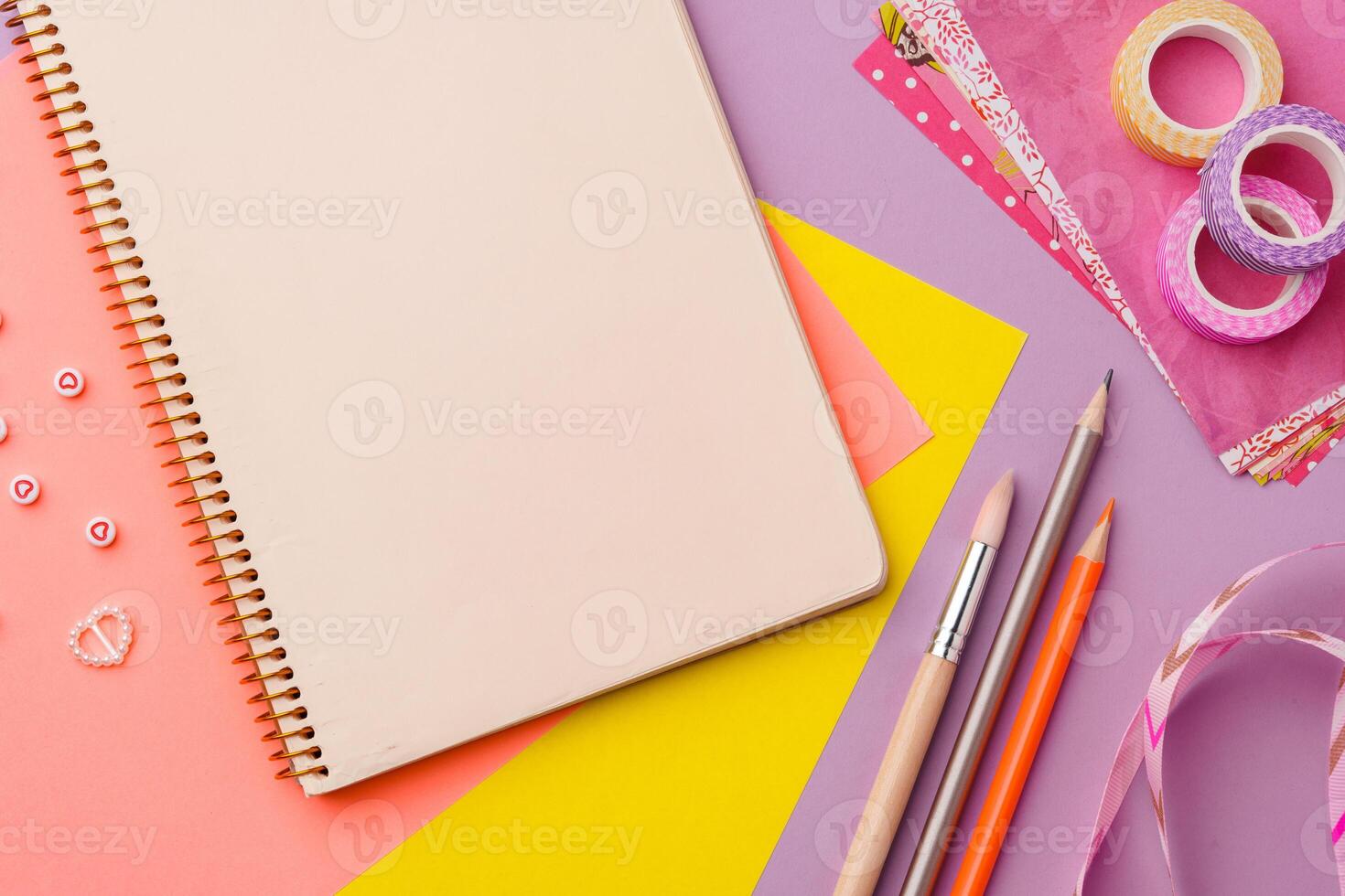 Scissors and decorative tape on colorful craft paper in a bright workspace photo