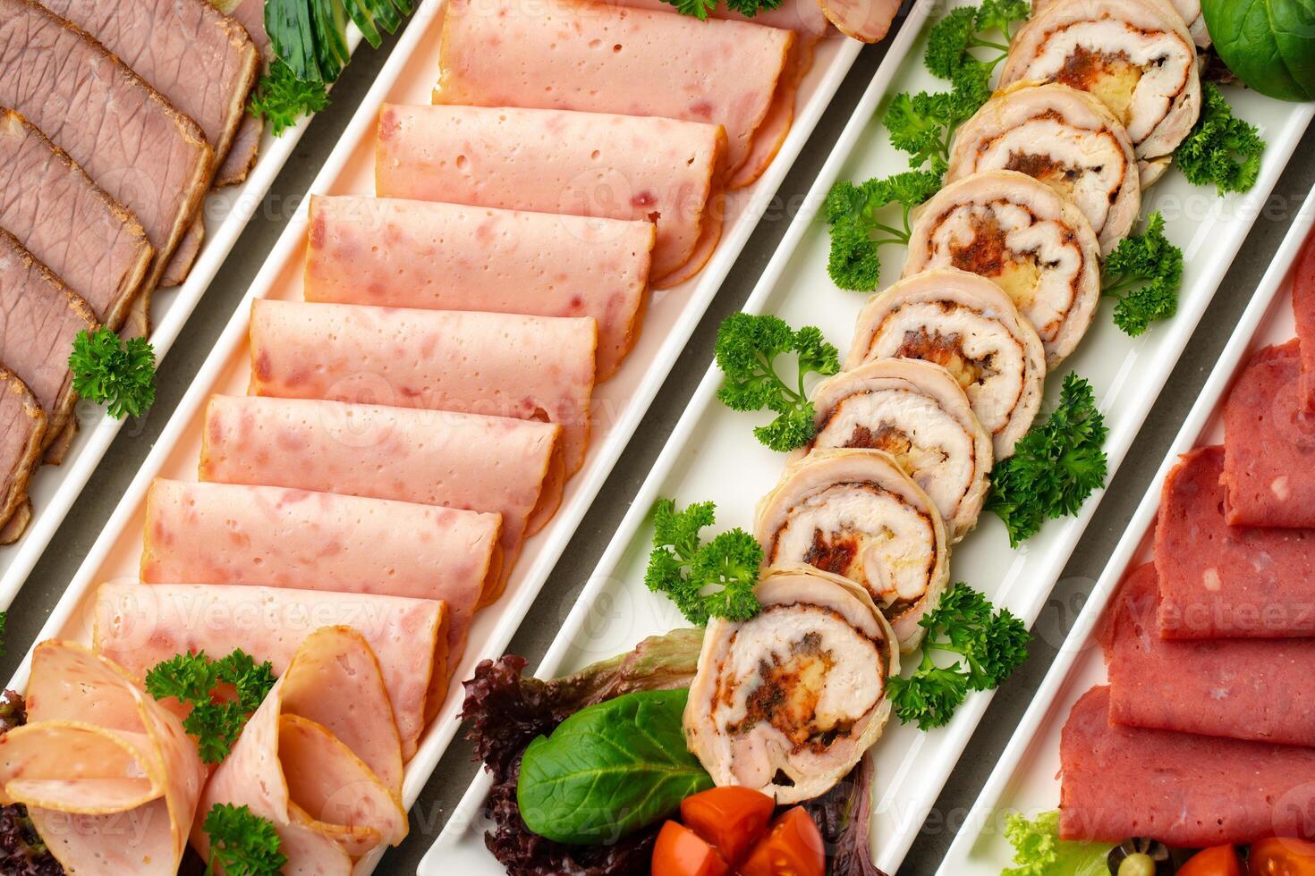 Platter of fresh meat cold cuts with vegetables. photo
