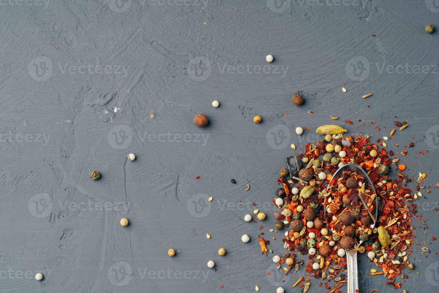 Colourful various herbs and spices for cooking on dark background photo
