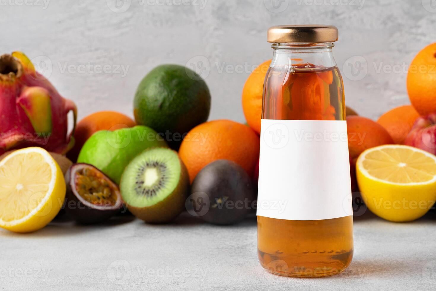 Various fruits and freshly squeezed fruits juice in bottle on gray background photo