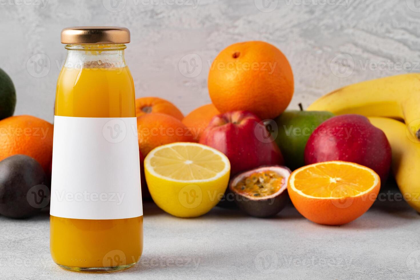 Various fruits and freshly squeezed fruits juice in bottle on gray background photo