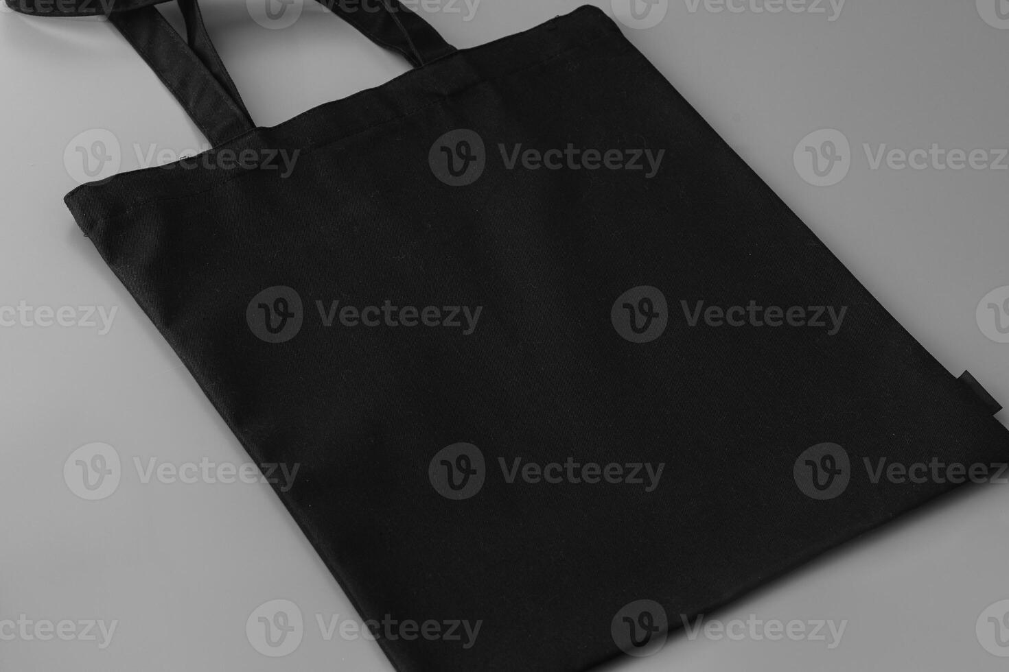 Black empty textile bag on gray background photo