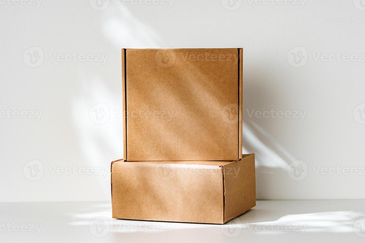 Freshly packed cardboard boxes resting on a white surface, illuminated by soft natural light photo