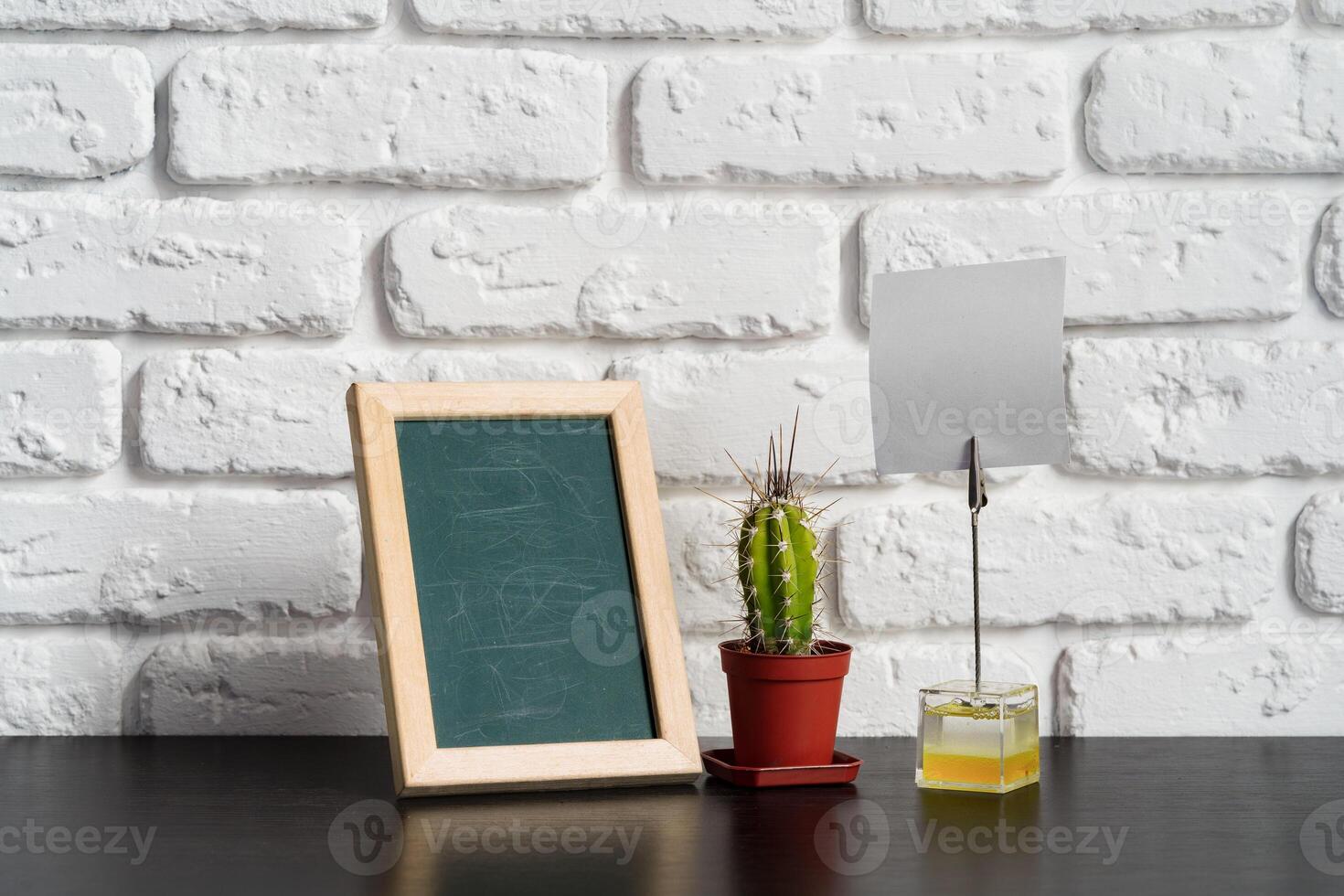 Wooden picture frame on a table with cactus photo