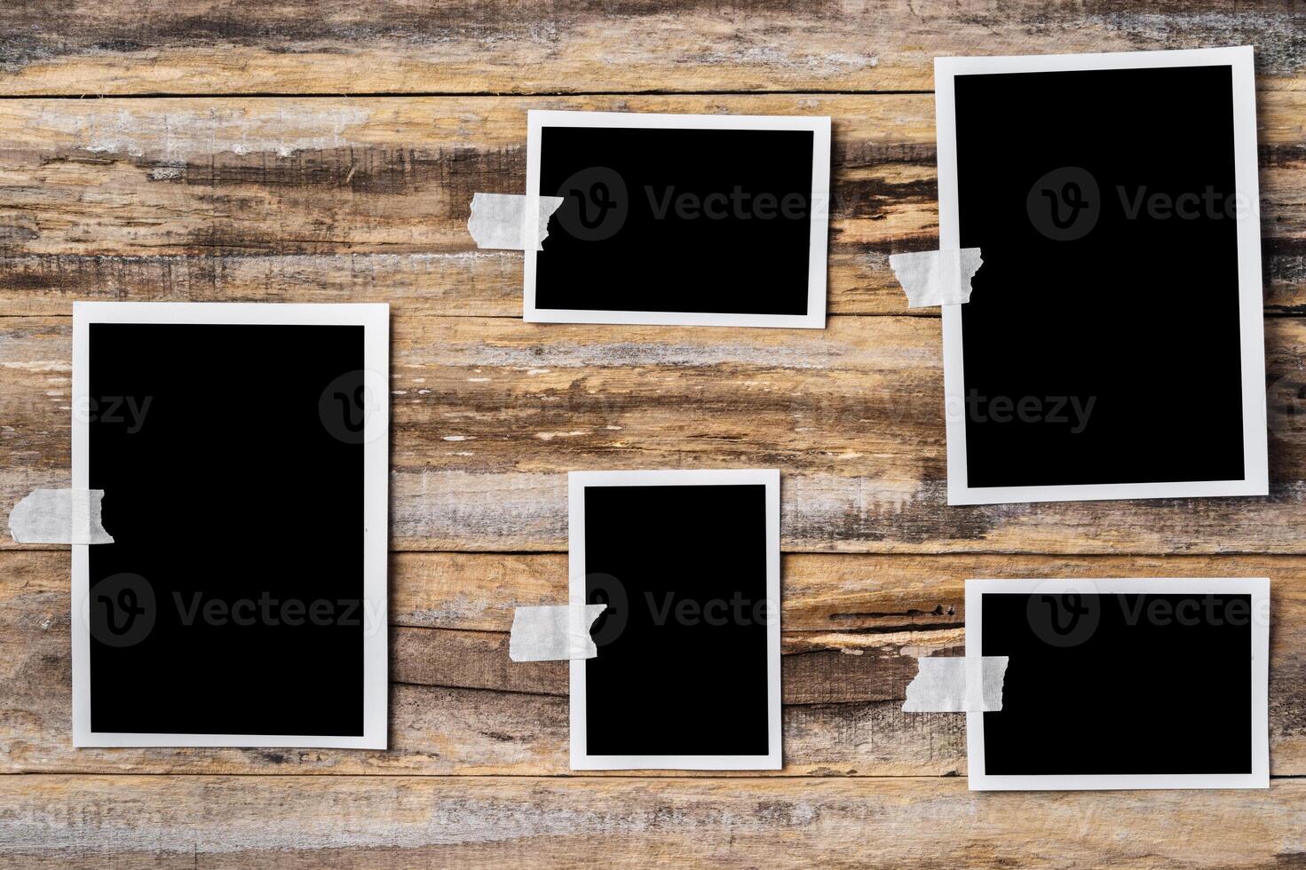 Paper blank photo frames hanging on wooden wall