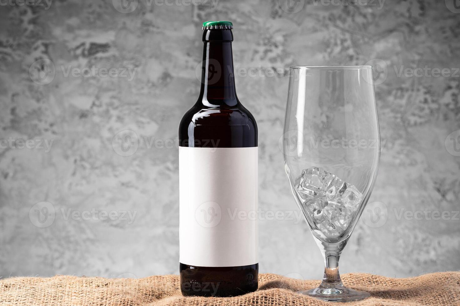 Beer bottle and beer glass against gray background photo