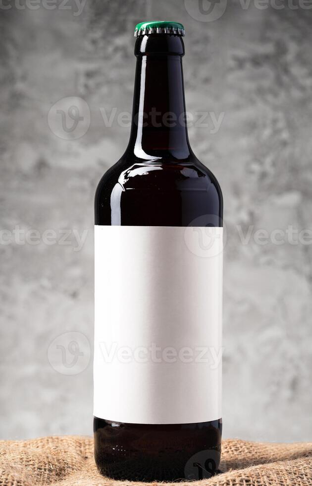 Beer bottle with blank label against gray textured background photo