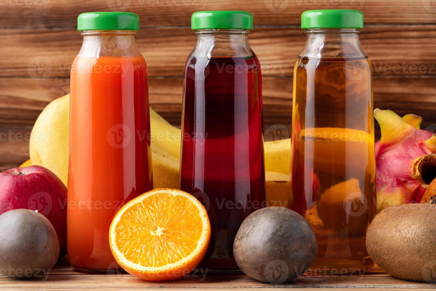 Fruits and freshly squeezed fruits juice on wooden table photo