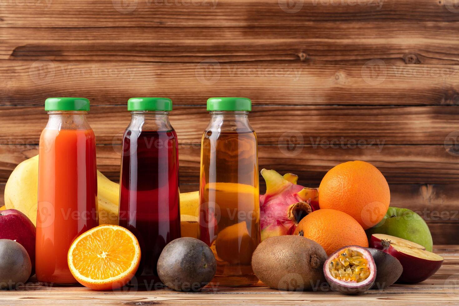 Fruits and freshly squeezed fruits juice on wooden table photo