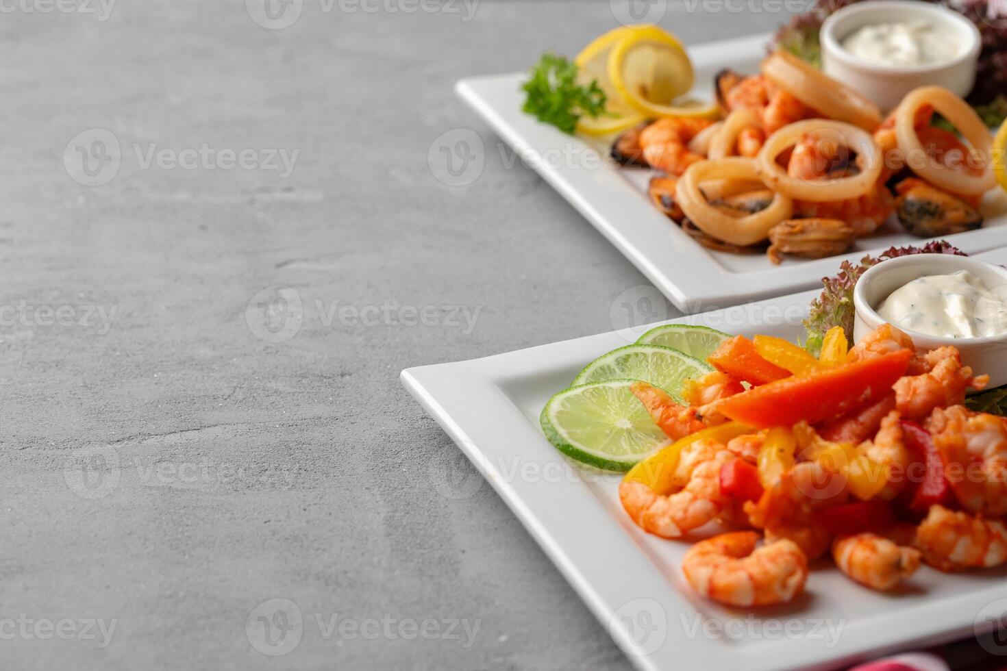 Cooked seafood on plate on gray background photo
