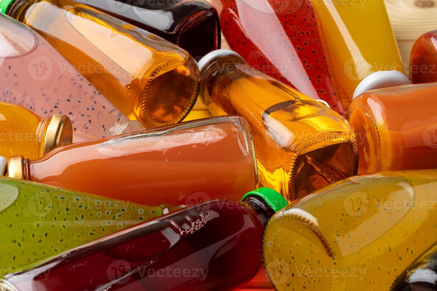 Different bottles of juice on wooden table photo