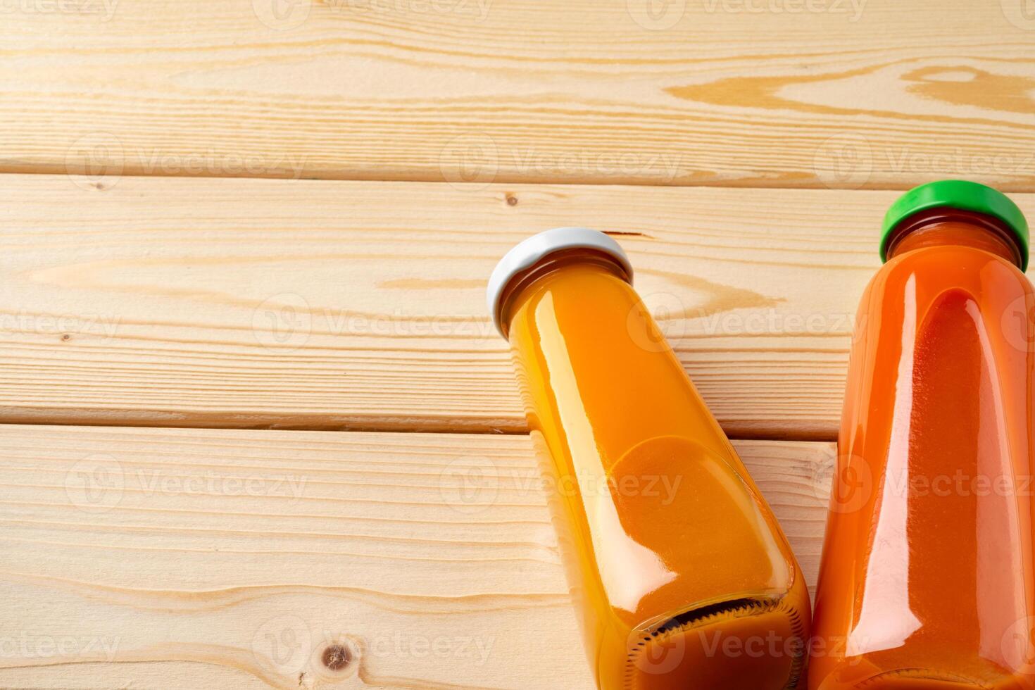 Juice bottles on wooden background flat lay photo