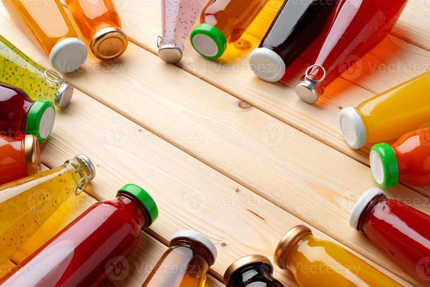 Different bottles of juice on wooden table photo