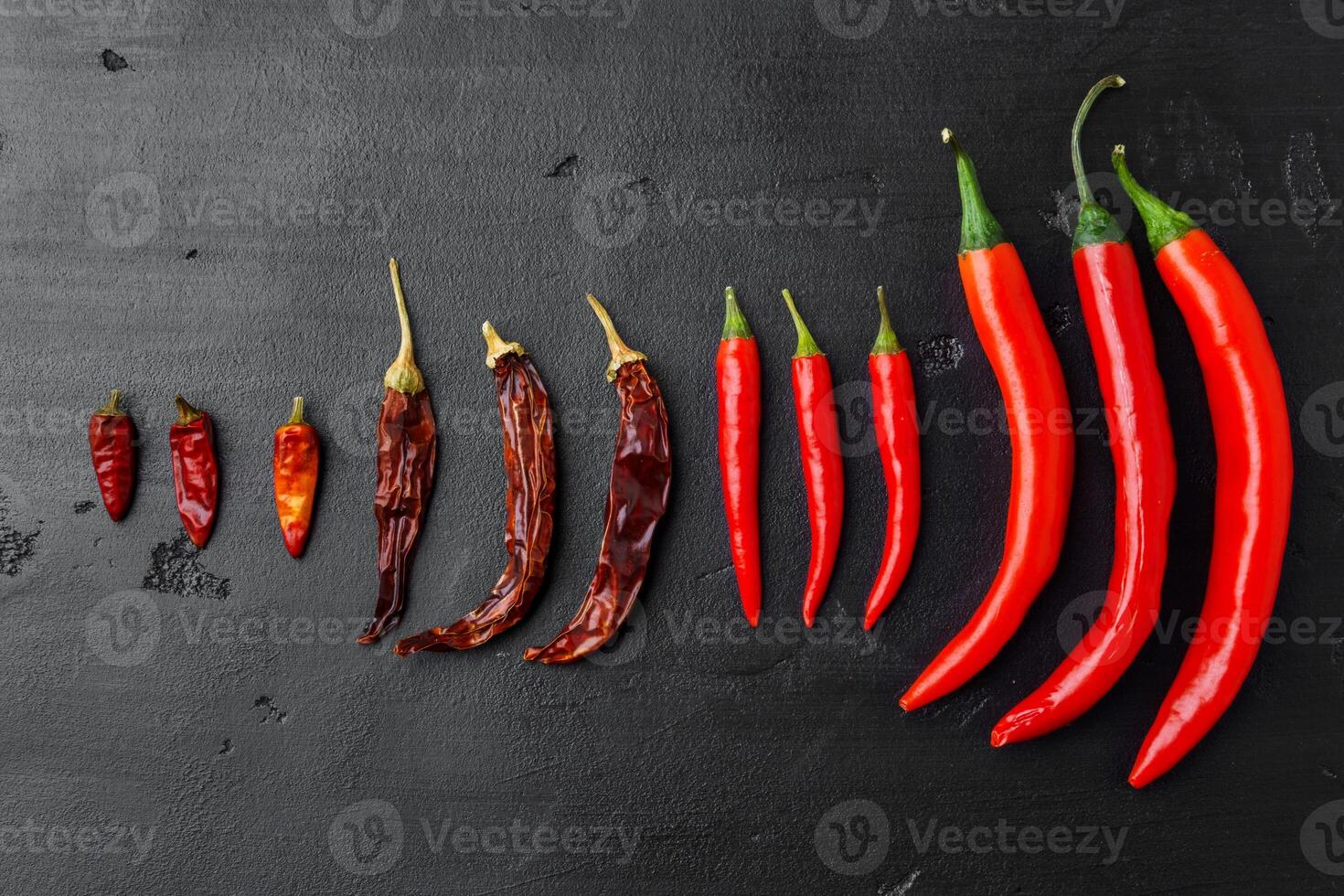 Red peppers on a black background top view photo