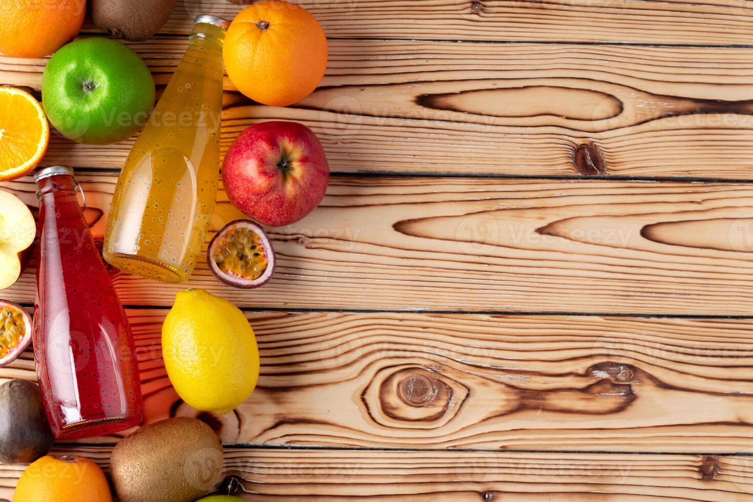 Fruits and freshly squeezed fruits juice on wooden table photo