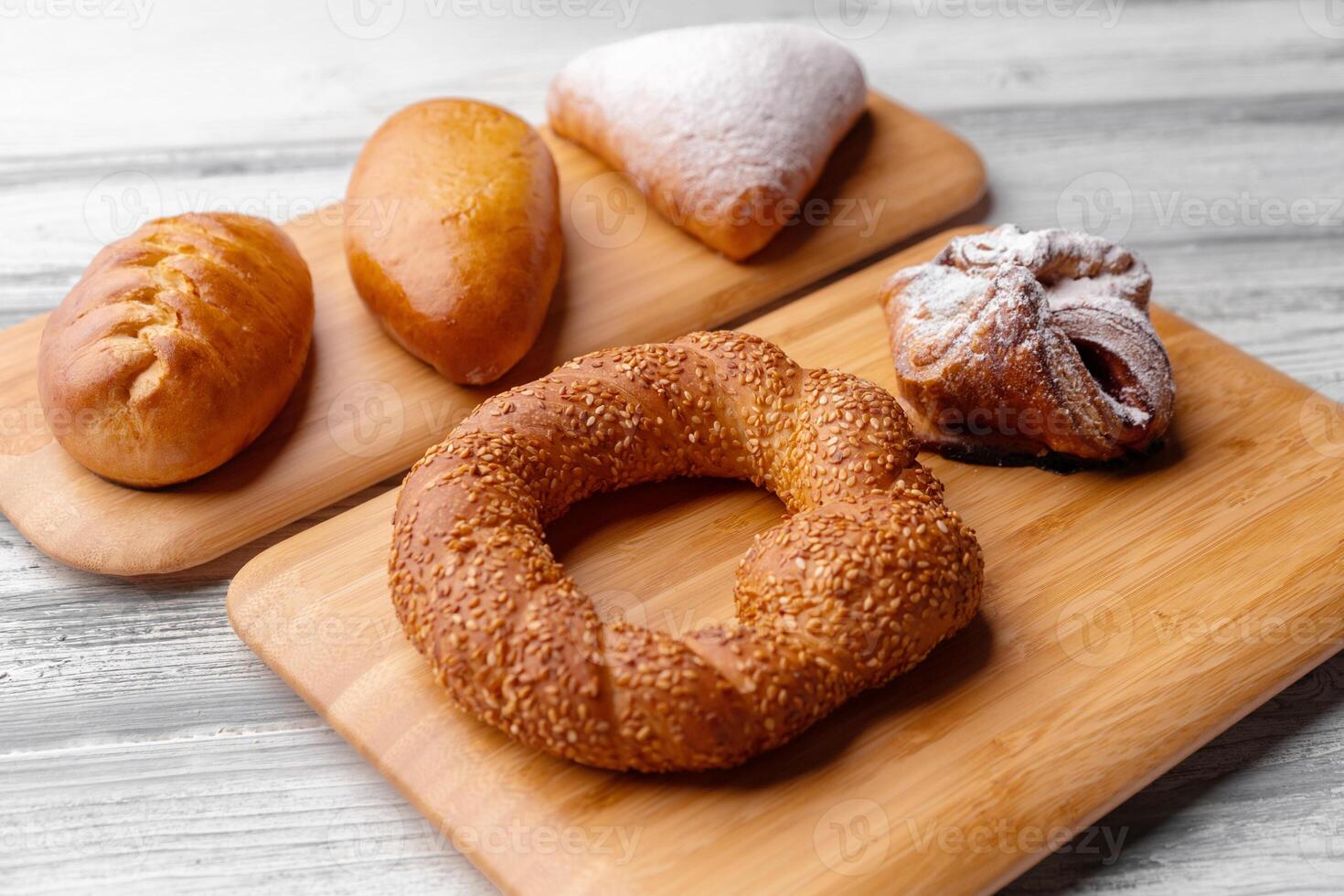 Various freshly baked sweet buns on wooden background photo