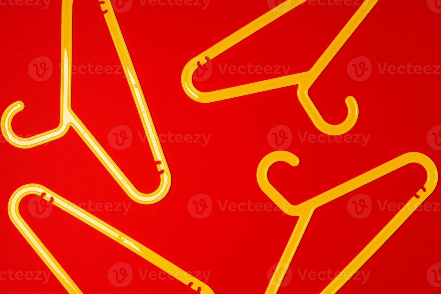 Hanger on red paper background. Minimalistic fashion concept. Top view photo