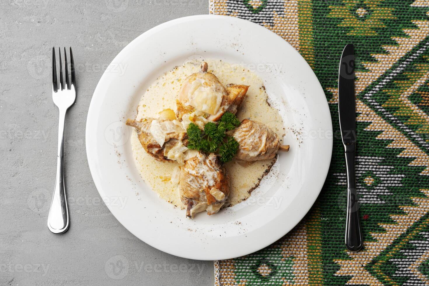 Chicken stewed in a creamy sauce on white plate photo