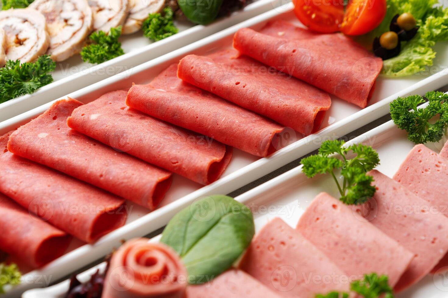 Platter of fresh meat cold cuts on table photo