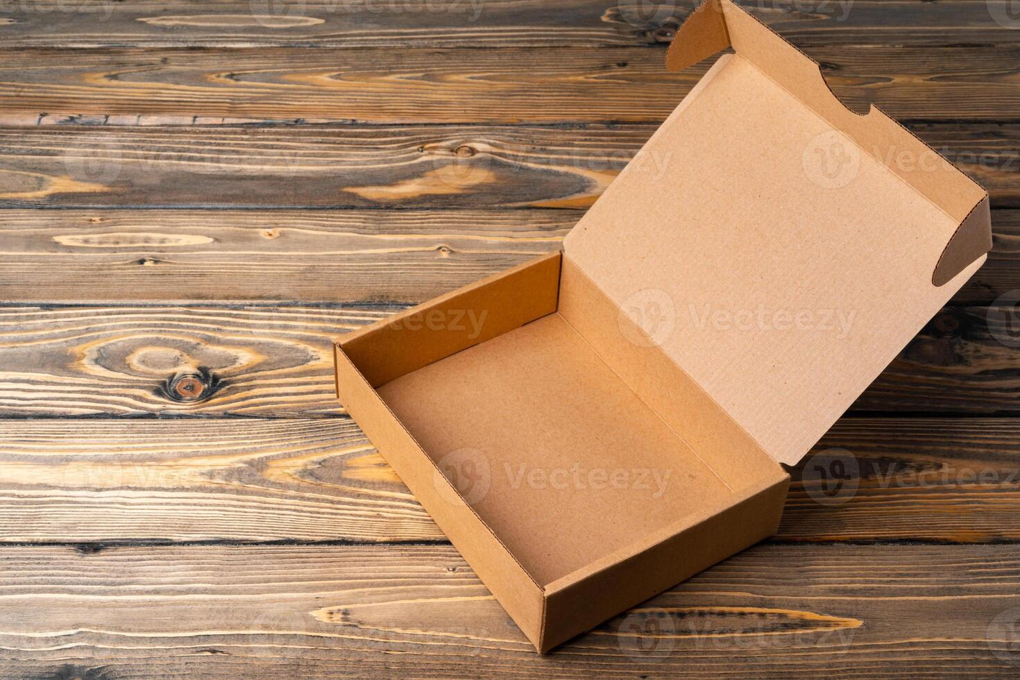 One open cardboard box on wooden background photo