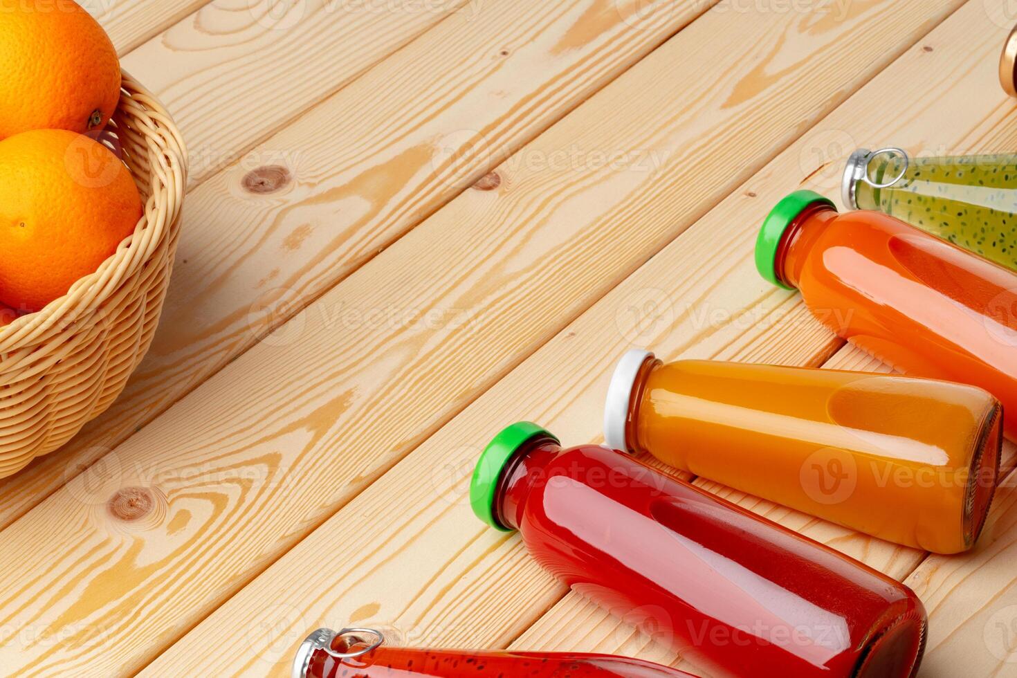 Different bottles of juice on wooden table photo