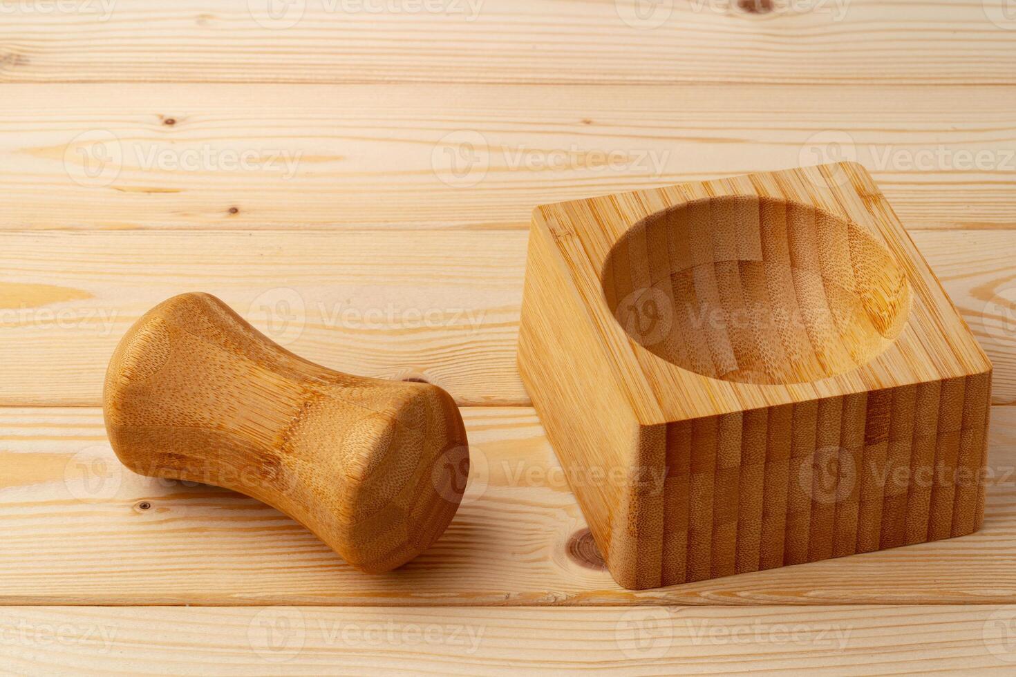 Wooden mortar with pestle on wooden background photo