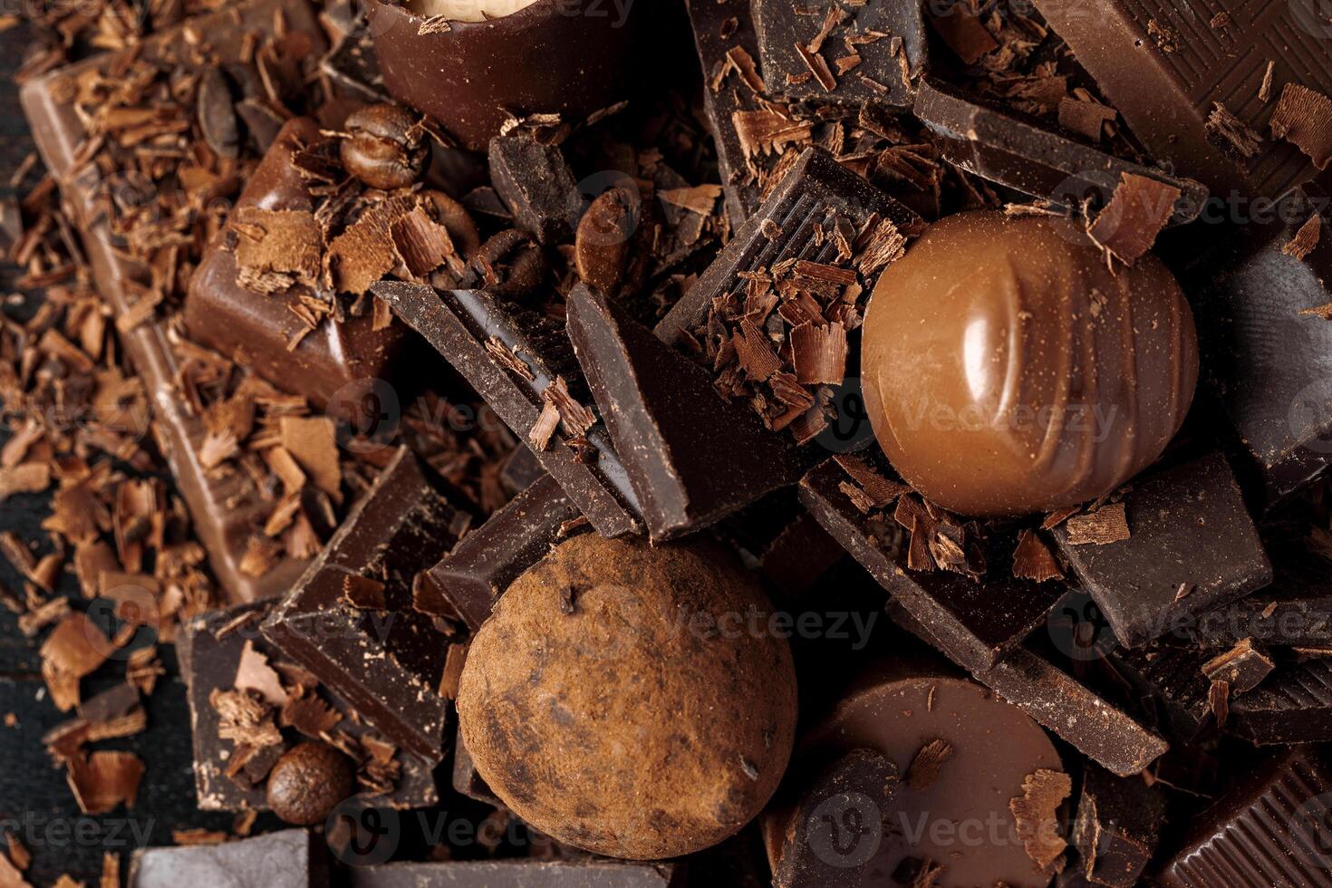 Grated chocolate and pieces of tasty chocolate on table photo