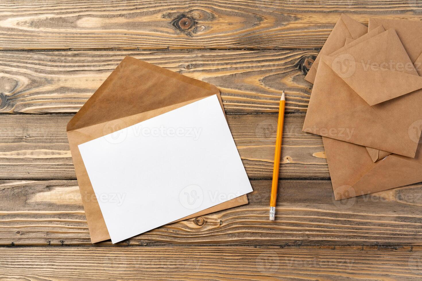 Vintage envelope with empty card, pen on wooden table top view photo